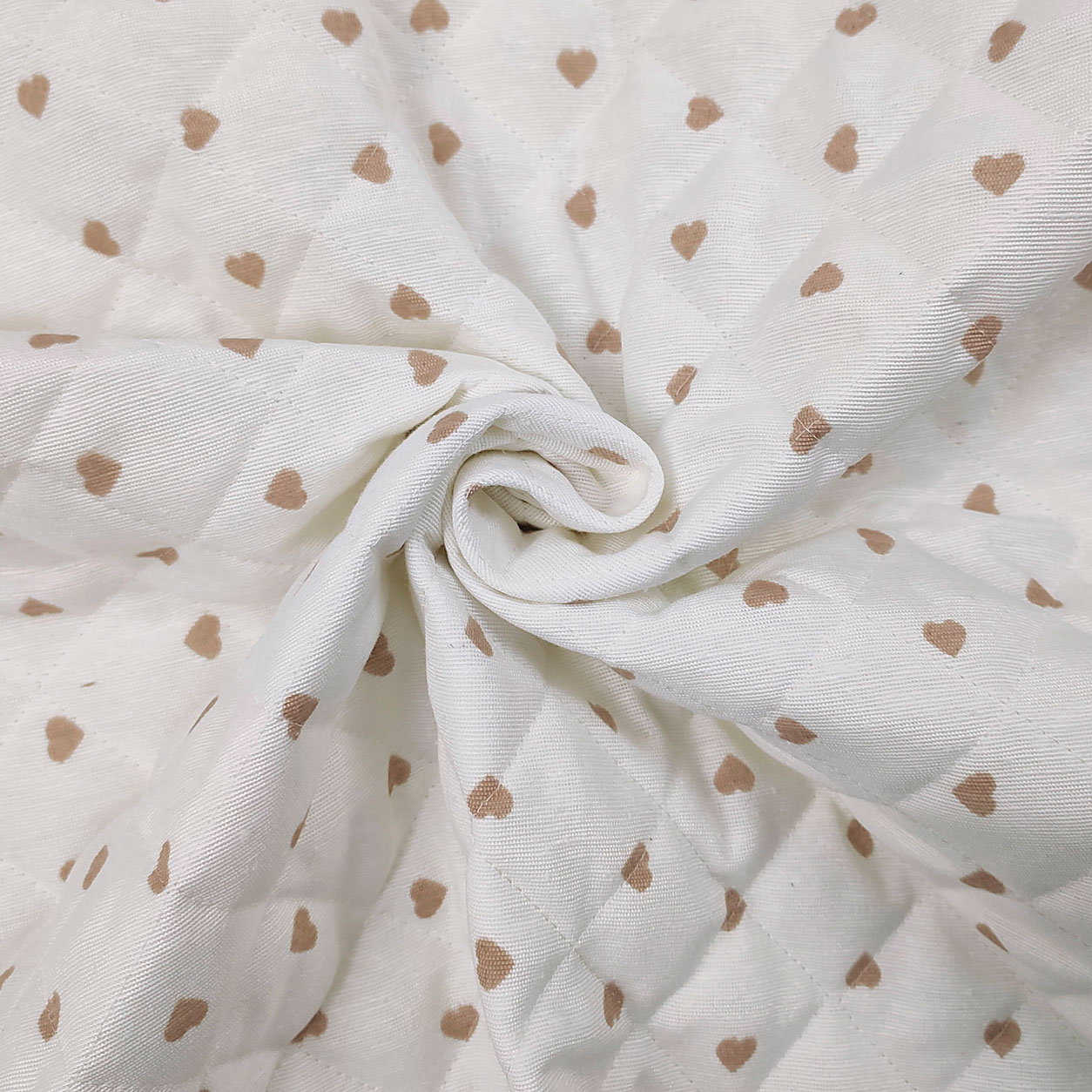 Tessuto trapuntato cuoricini beige