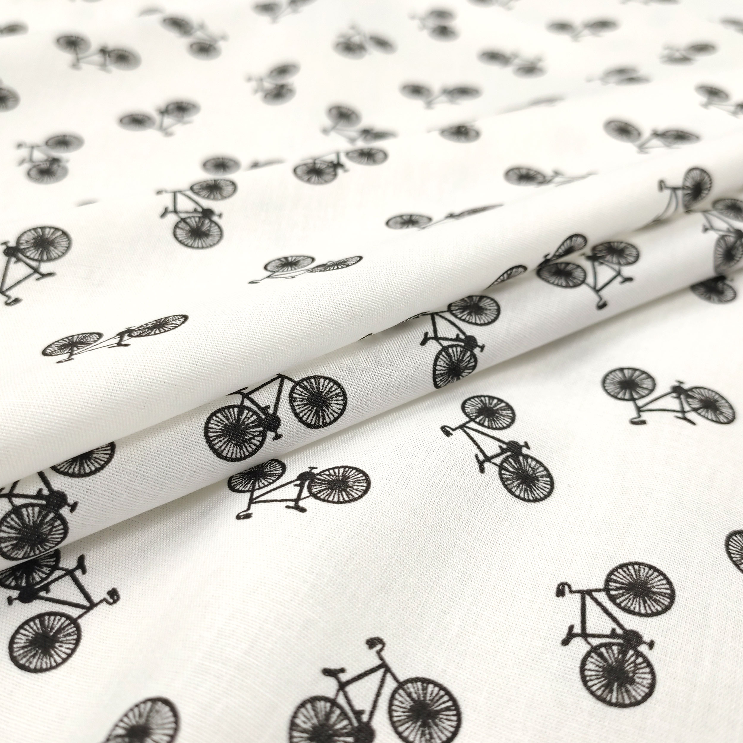 tessuto in cotone con fantasia bici mini nere sfondo bianco