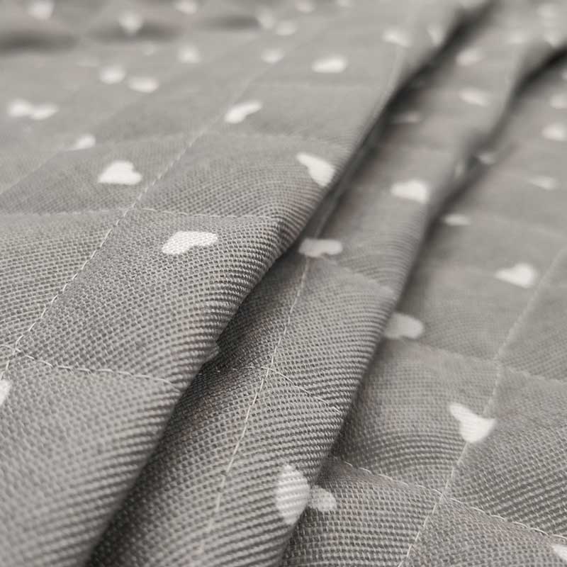 Tessuto trapuntato cotone cuori bianchi sfondo grigio